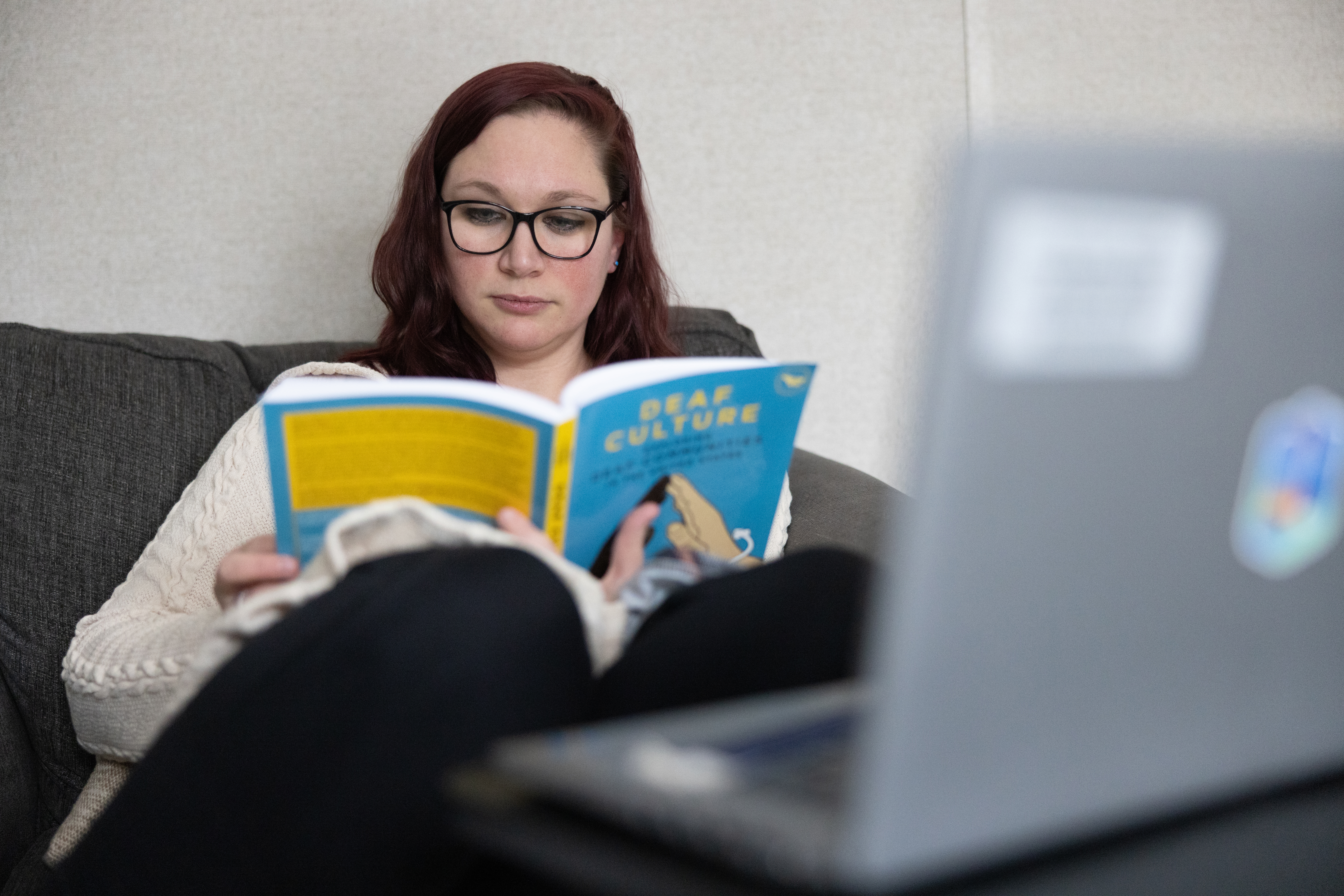 Danielle P. reads the book Deaf Culture.