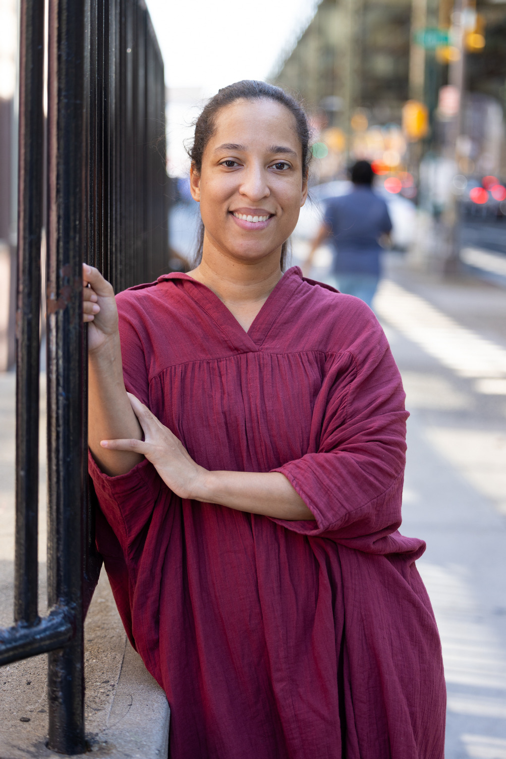 photo of student smiling outside on city street holding a railing