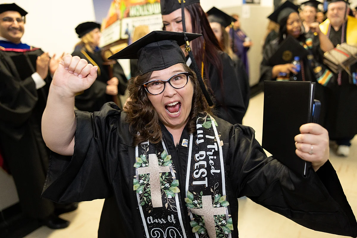 Woman in cap and gown at commencement ceremony in Rochester.