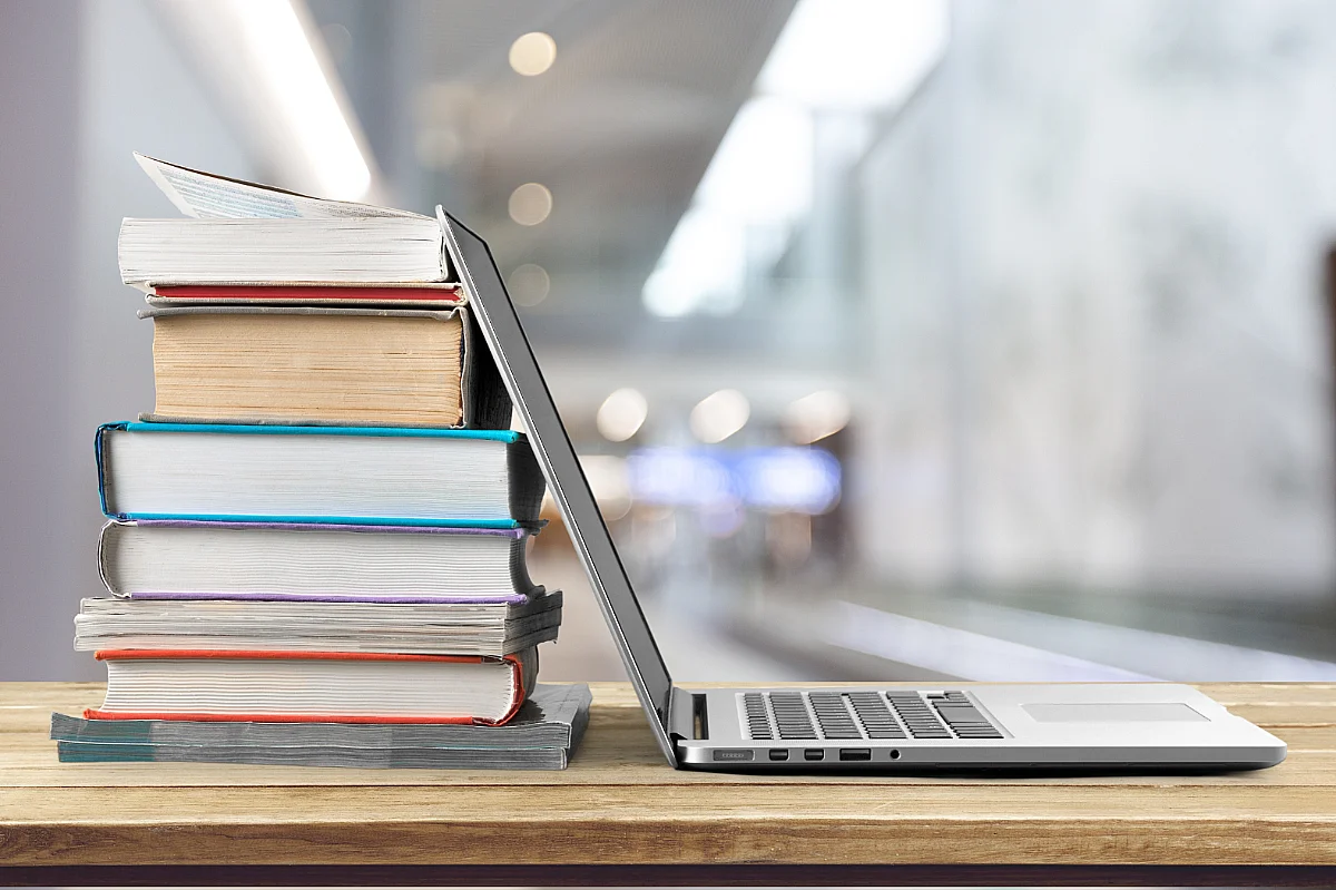 a stack of books near a laptop