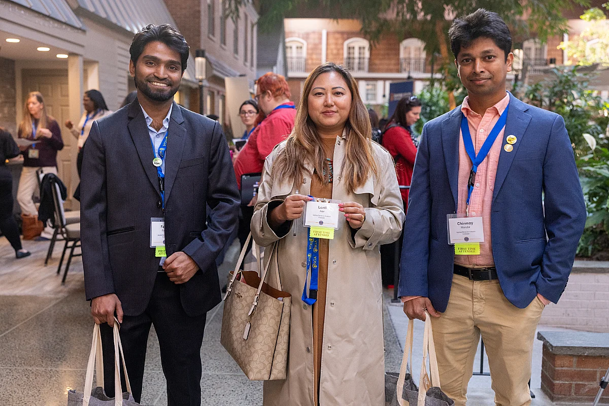 Two men and a women attend a student conference.