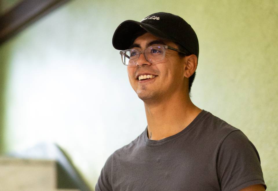 student smiles for a photo on a staircase