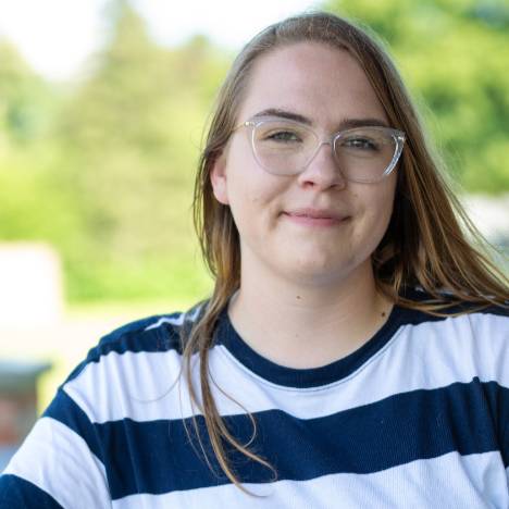 student poses for a photo outside