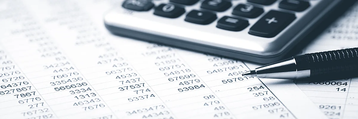 photo of spreadsheet, calculator, and pen