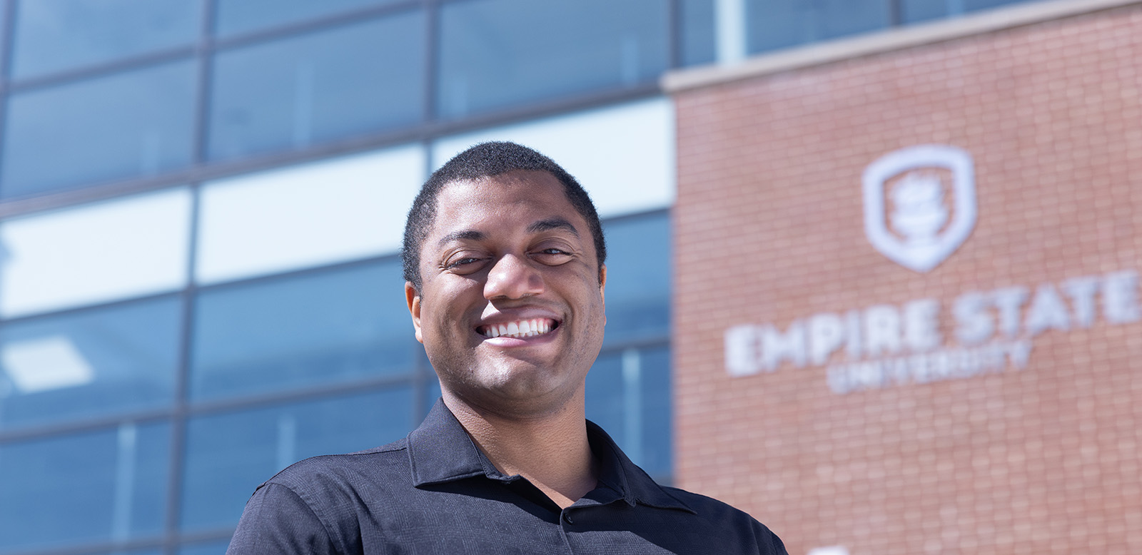 Student standing in front of a SUNY Empire building