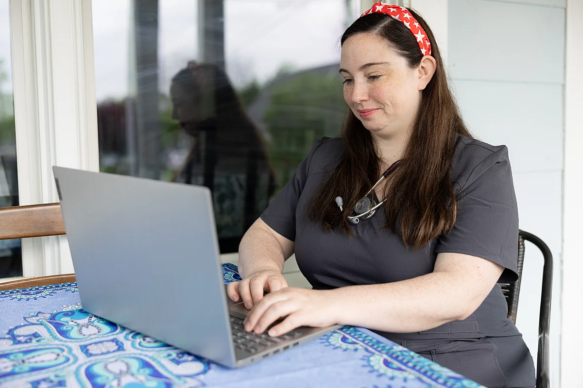A woman works at a laptop computer.