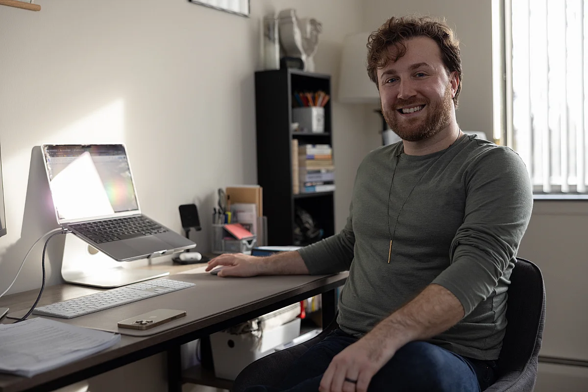 student sits at desk in their home