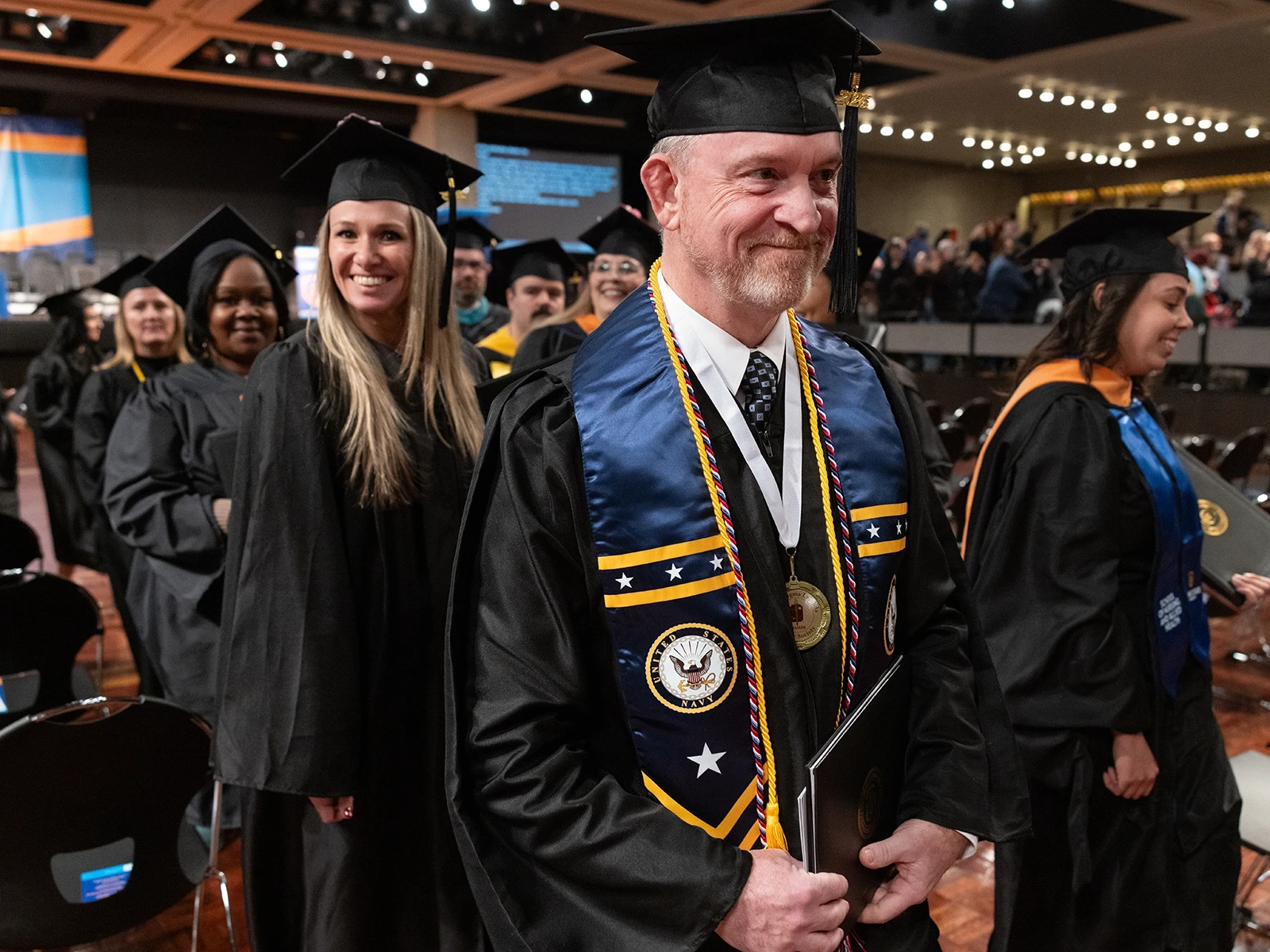 Student smiling while walking after graduating