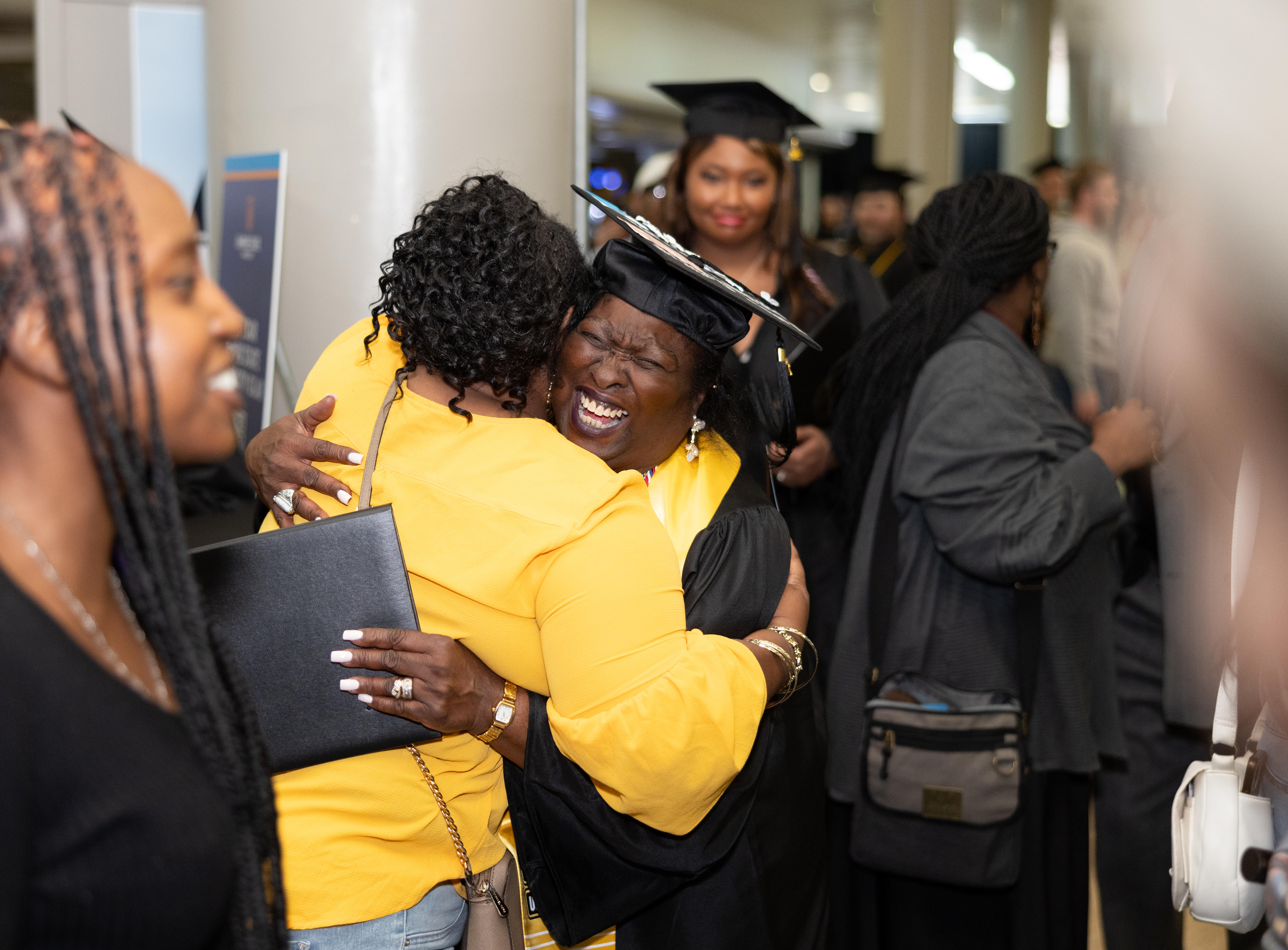 A woman hugs a female graduate after the Rochester commencement ceremony.