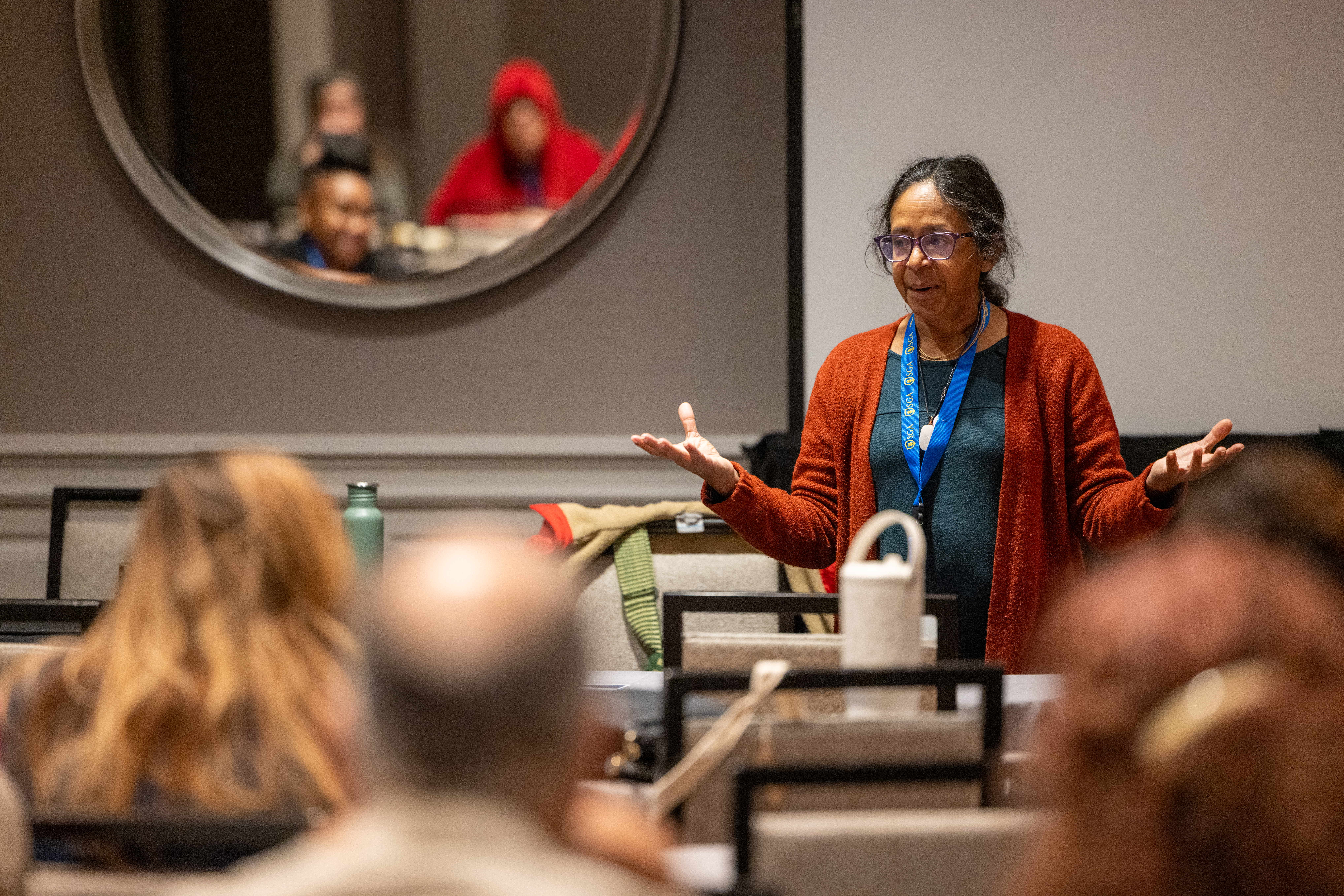 A woman faculty member speaks to a group of students.
